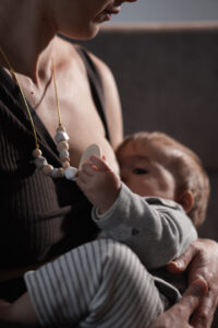 Mujer amamantando a su bebé, fundadora de LuluMoon, marca de collares de lactancia y accesorios para madres y bebés