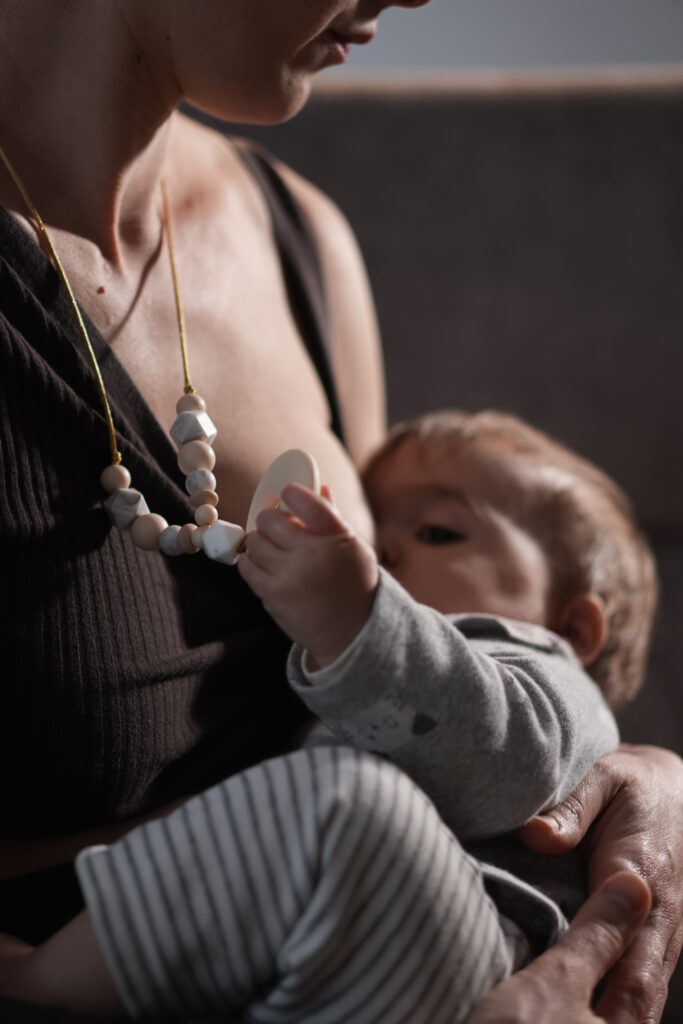 Mujer amamantando a su bebé, fundadora de LuluMoon, marca de collares de lactancia y accesorios para madres y bebés