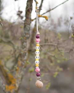 Imagen con varios productos de Lulu Moon: collares de lactancia, mordedores sensoriales y chupeteros personalizados hechos a mano.