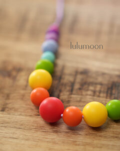 Collar de apego RAINBOW, pieza sensorial hecha a mano para madres y bebés. Lulumoon.
