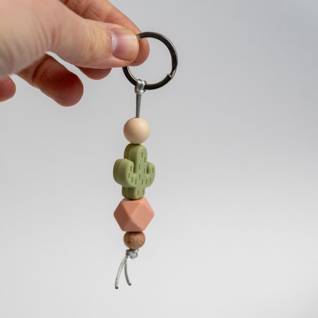 Llavero Lulumoon modelo Cactus Oliva con bola hexagonal en tono rosa tierra y madera de haya.