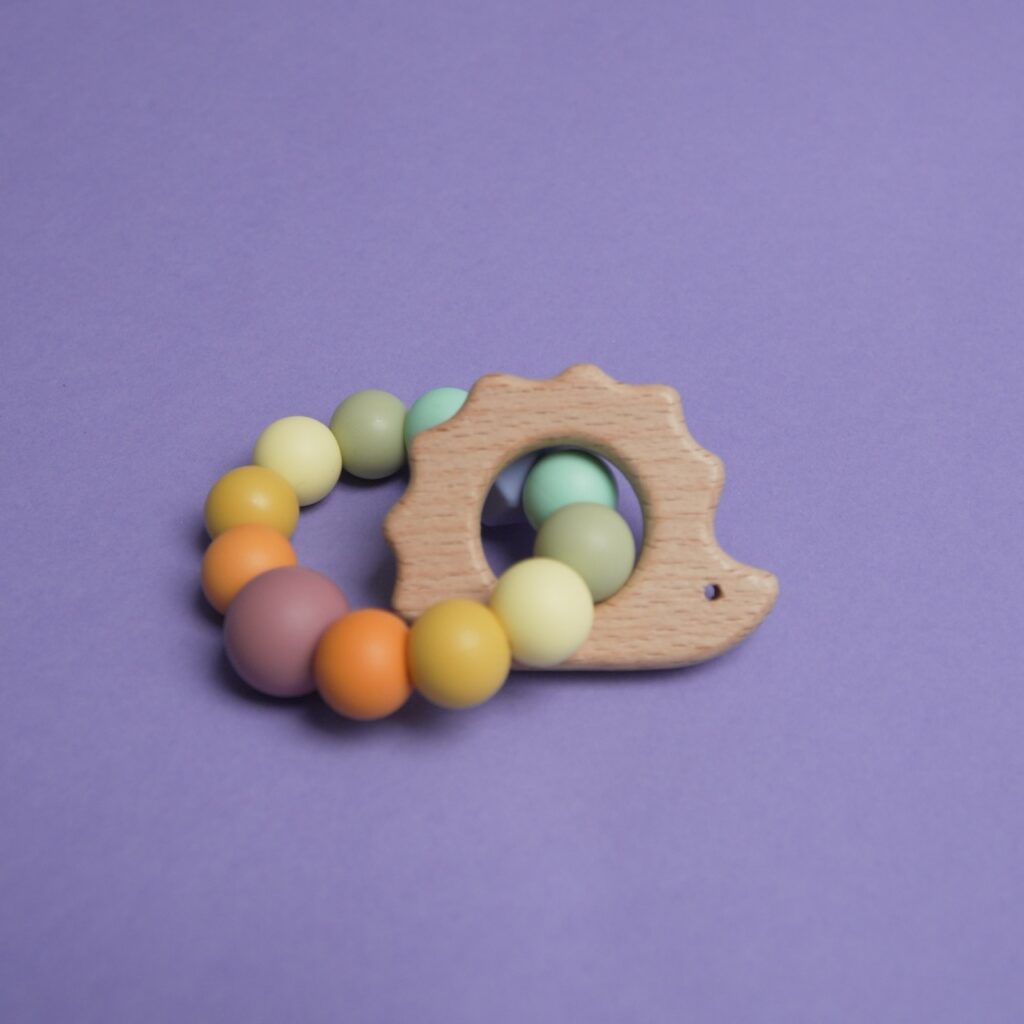 Mordedor de silicona y madera de haya con forma de erizo en tonos arcoíris, artesanía infantil de Lulumoon.