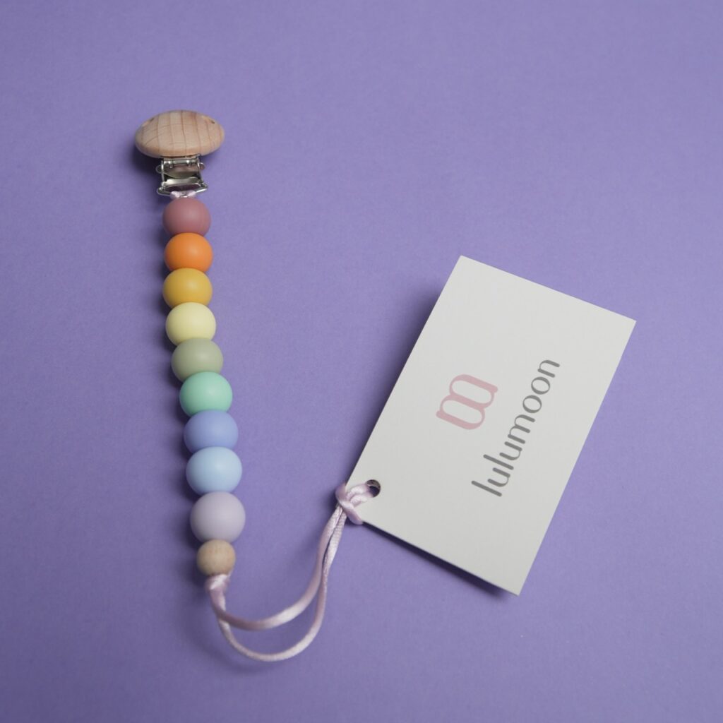 Chupetero personalizado de silicona arcoíris con clip de madera, un regalo seguro para bebés de Lulumoon Bebé.
